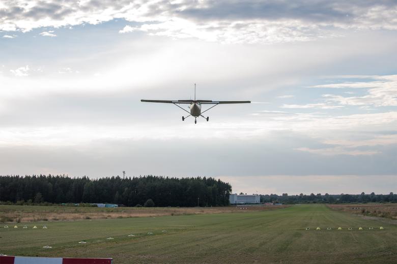 Awionetka lądująca na trawiastej drodze startowej