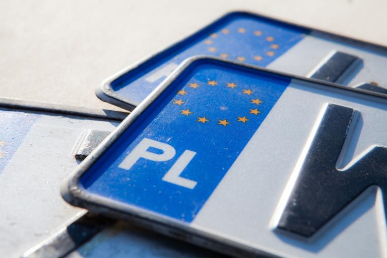 samochodowe tablice rejestracyjne z literkami PL oraz symbolem z żółtymi gwiazdkami tworzącymi okrąg na niebieskim tle