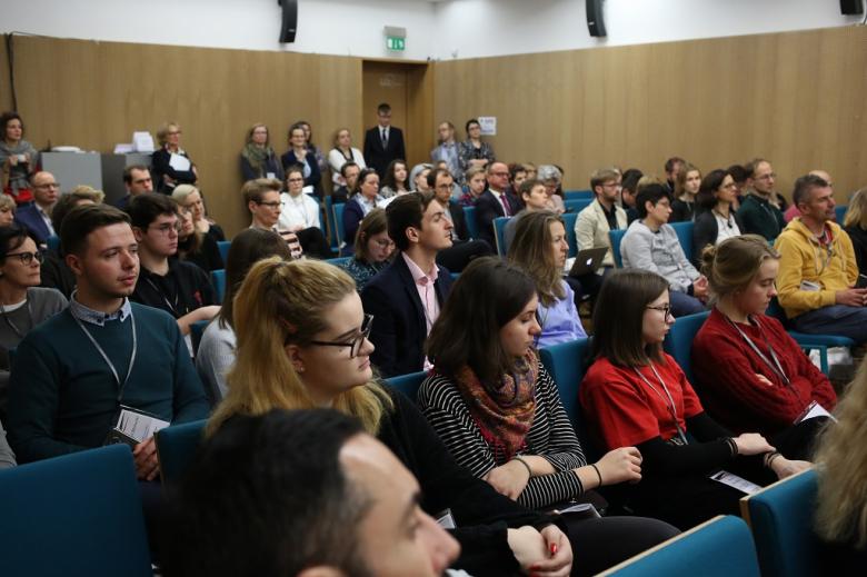 Pełna sala konferencyjna, zielone krzesla