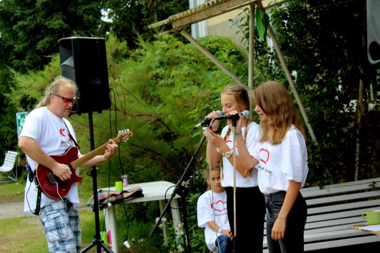 Zdjęcie: dwie dziewczynnki śpiewają, mężczyzna gra na gitarze