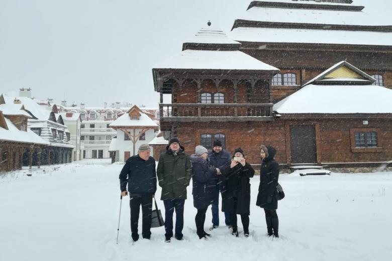 Zdjęcie grupowe w śniegu na tle drewnianych domów