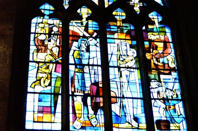 Witraż przedstawiający Świętą Rodzinę i ludzi z mieczami