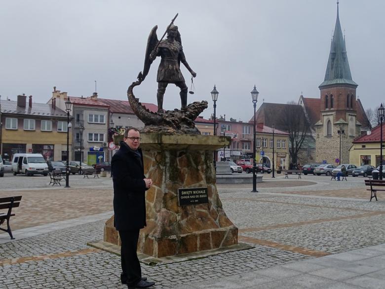 Mężczyzna przed pomnikiem św. Jerzego 