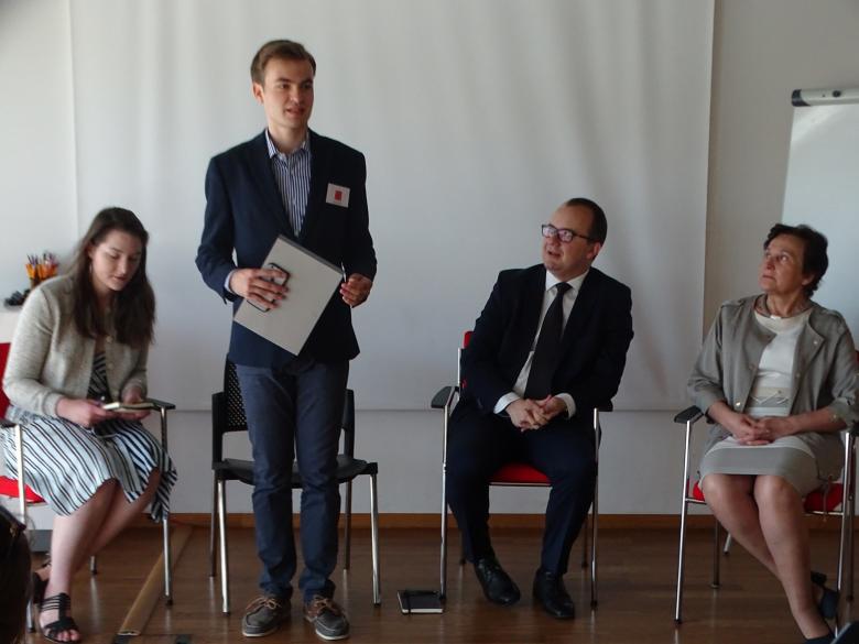 prelegenci siedzą podczas debaty