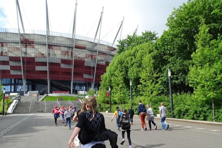 Dzieci biegną w stronę stadionu