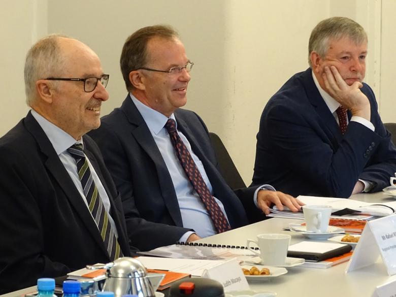 zdjęcie: trzej mężczyźni siedzą przy stole