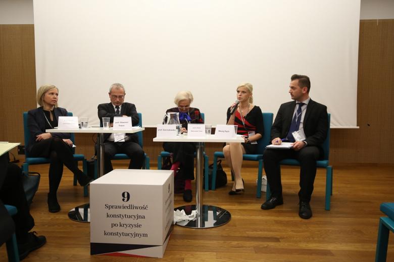 Paneliści i sześcian z tytułem panelu