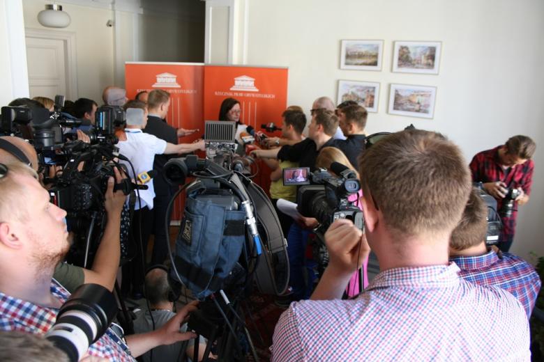 na zdjęciu prof. Irena Lipowicz otoczona przez dziennikarzy