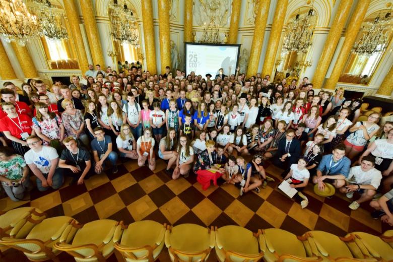 Osoby siedzą w sali 