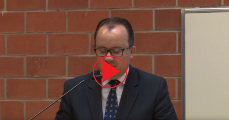 Mężczyzna na mównicy, znak "play"