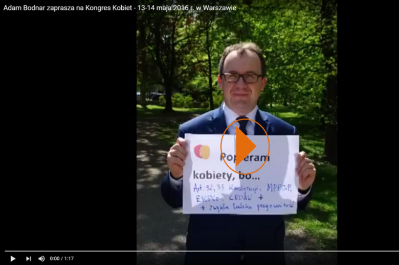 Adam Bodnar stoi w parku i trzyma dużą kartkę