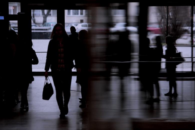 Niewyraźne sylwetki osób wchodzących do budynku