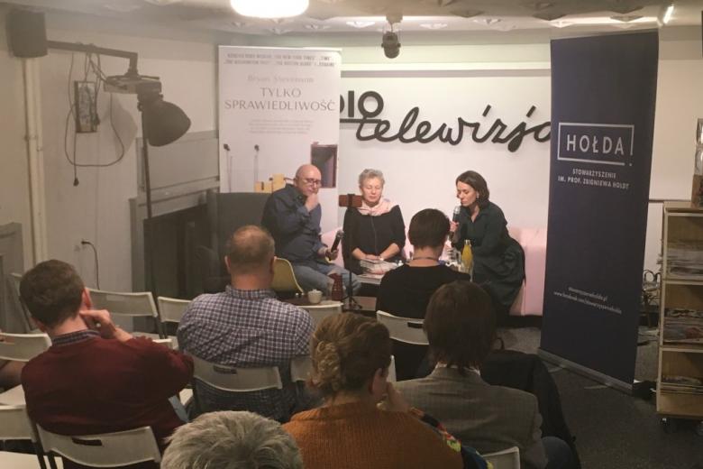 Trzy osoby rozmawiają na kanapie, na ścianie napis Radio i Telewizja