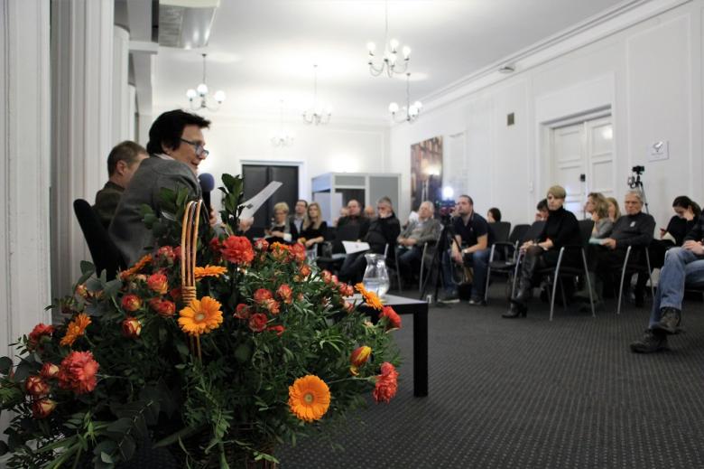 Osoby siedzą w sali 
