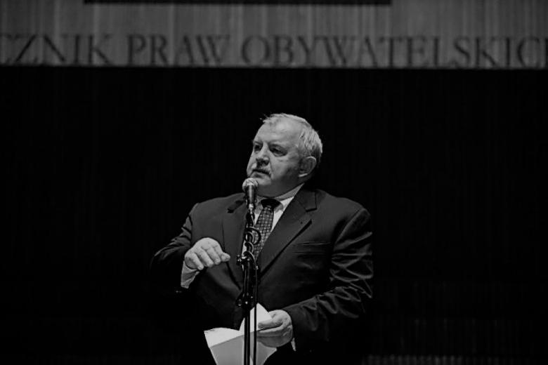 Mężczyzna w średnim wieku stoi na scenie. Zdjęcie czarno-białe