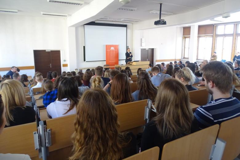 Aula uniwersytecka pełna ludzi, wykład, ujęcie ze skosu