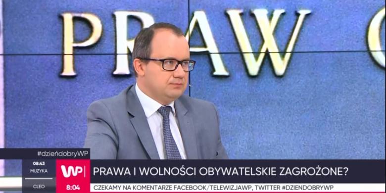 zdjęcie: mężczyzna w jasnym garniturze i okularach