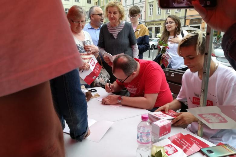 Mężczyzna podpisuje Konstytucję pod namiotem