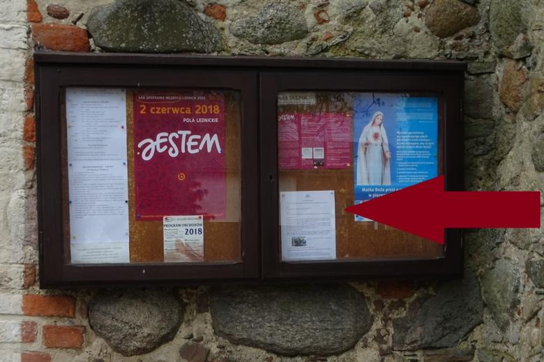 Gablota z ogłoszeniami parafialnymi, na jednym z plakatów wizerunek Matki Boskiej