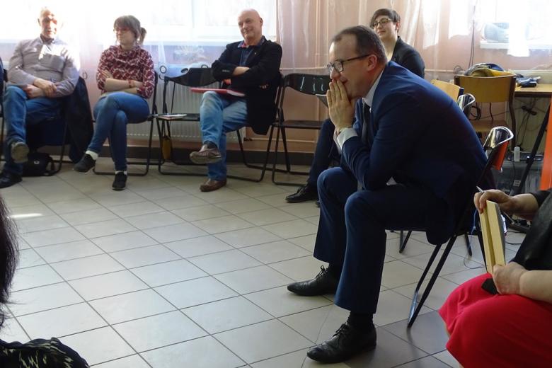 Uśmiechnięty meżczyzna słucha w skupieniu