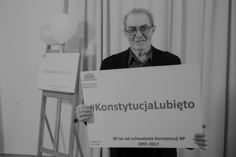 Mężczyzna trzyma napis "Konstytucja Lubię to"