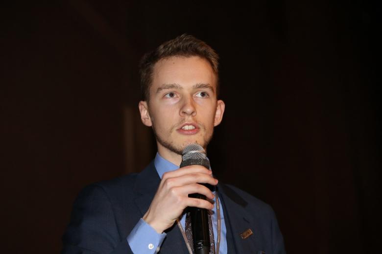 Bardzo młody mężczyzna w garniturze zadaje pytanie