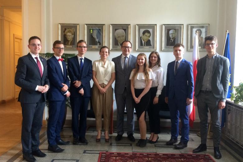 ludzie stojący na tyle ściany z portretami