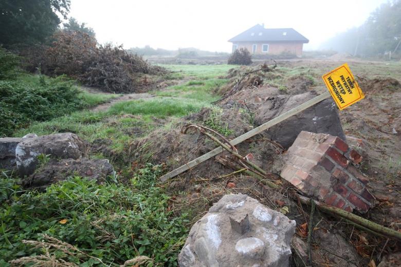 Zwalone płyty nagrobne i przekrzywiona tablica Robioty budowlane