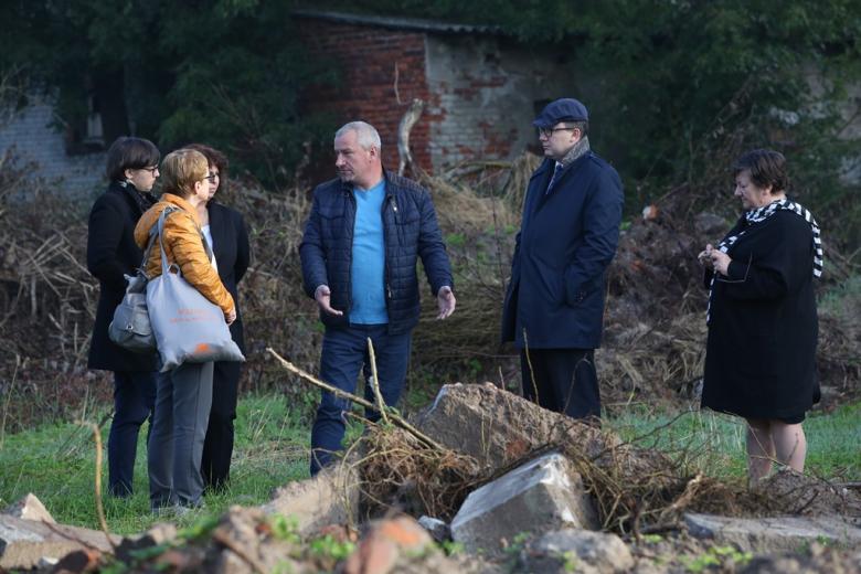 Ludzie wśród zwalonych plyt nagrobnych