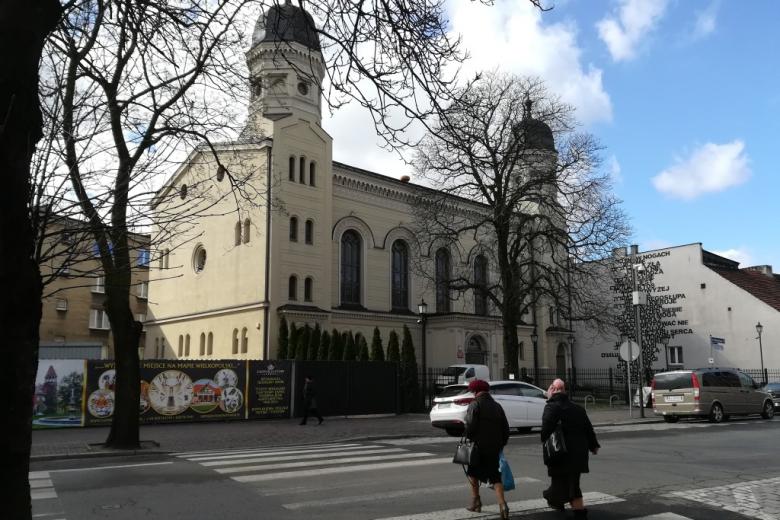 Wysoki biały budynek z dwoma wieżami po bokach