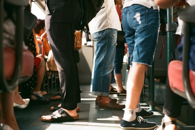 Sylwetki ludzi stojących w autobusie