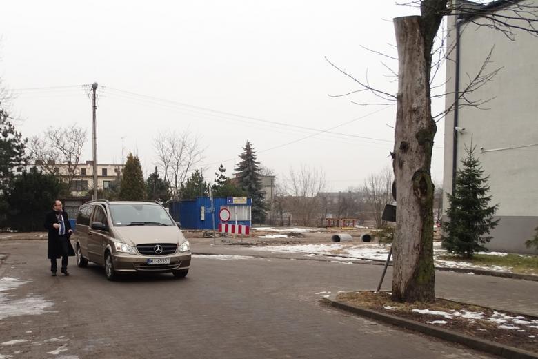 Męzczyzna wysiada z samochodu na parkingu