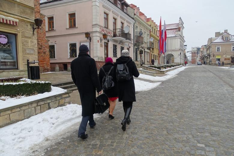 Troje ludzi idzie przez zabytkowe miasto