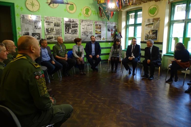 Ludzie w kręgu, część w mundurach harcerskich