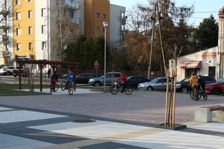 Młodzi ludzie ćwiczą akrobacje rowerowe na placyku