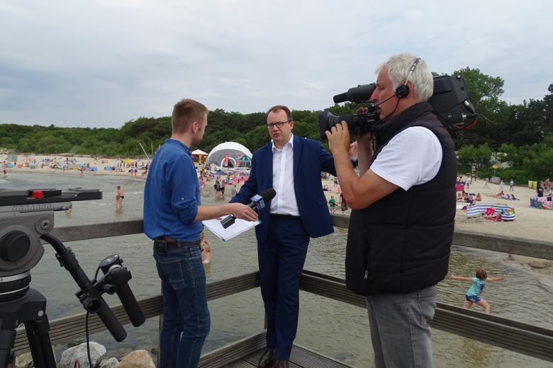 Zdjęcie: kamerzysta, reporter i Adam Bodnar na plaży