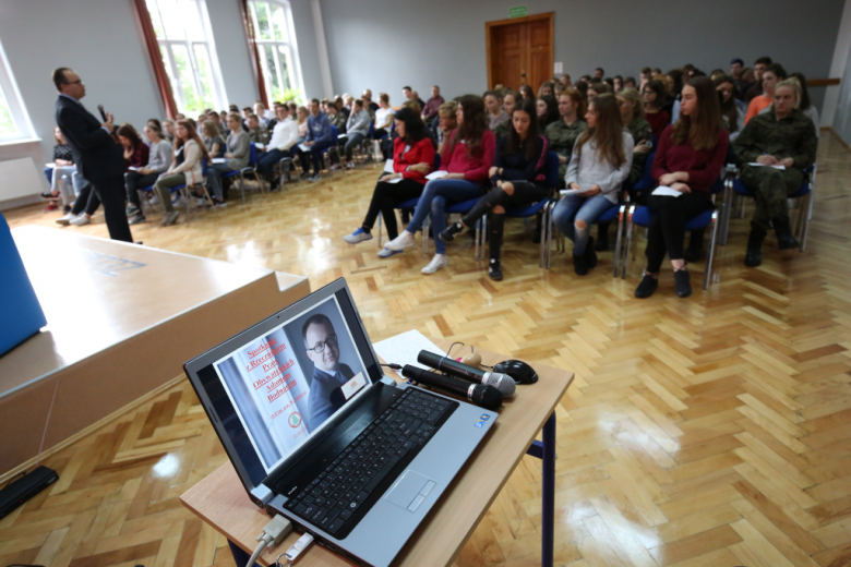 Młodzi ludzie na sali, trzymają puste karteczki