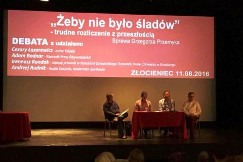 Zdjęcie: paneliści siedzą pod tytułem panelu na czerwonym tle