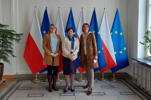 osoby stoją pozując do fotografii na tle flag polski i ue