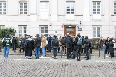 grupa młodych ludzi stojących przed budynkiem 