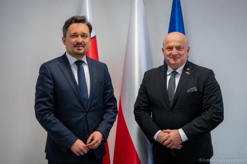 RPO Marcin Wiącek oraz marszałek województwa lubelskiego Jarosław Stawiarski pozują do zdjęcia na tle flag Polski i UE