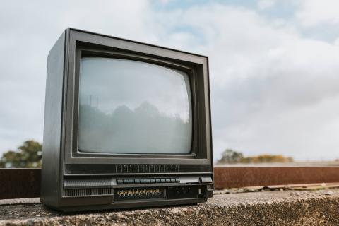 Czarny telewizor kineskopowy stojący przy krawężniku