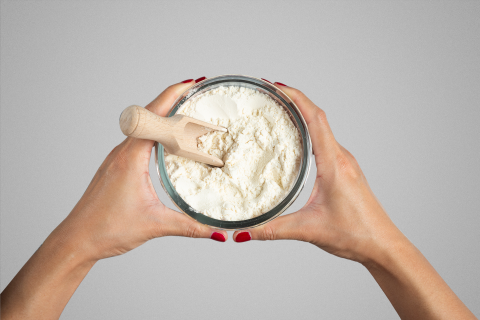 Dłonie kobiety trzymające słój z białym proszkiem - formułą dla dzieci