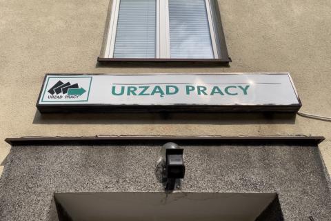 tablica z  napisem Urząd Pracy nad wejściem do budynku