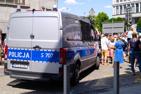 policyjna furgonetka obok demonstrantów   