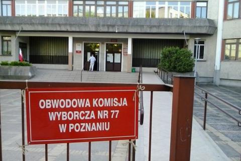 tablica na ogrodzeniu z napisem obwodowa komisja wyborcza