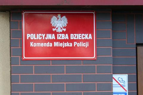 tablica na budynku z napisem Policyjna Izba Dziecka 