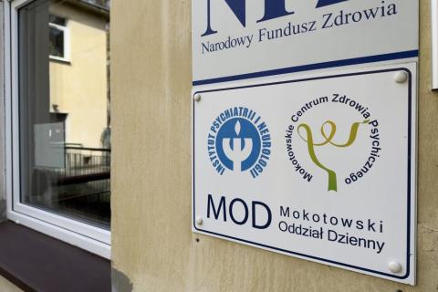 Tablica na ścianie z napisem Mokotowskie Centrum Zdrowia Psychicznego 