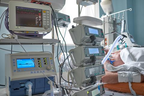 Aparatura medyczna stojąca obok łóżka z pacjentem na oddziale intensywnej terapii