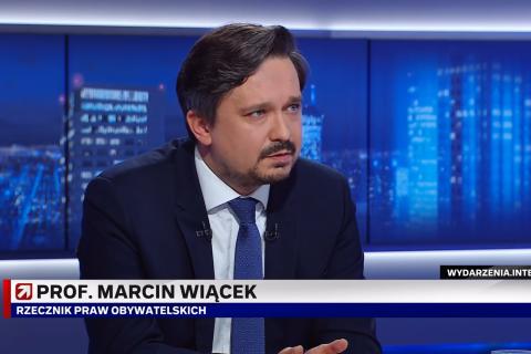 Zrzut ekranu programu telewizyjnego przedstawiający RPO Marcina Wiącka siedzącego w studiu